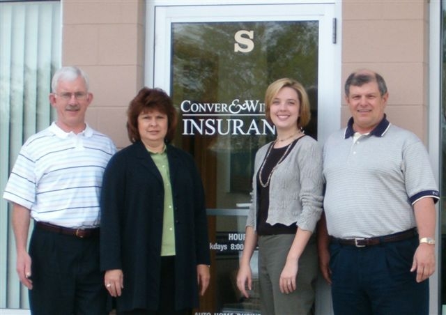 Barry Conver, Mary Jalbert, Sara McLean and Dennis Winchell standing outside the Conver & Winchell Insurance office door